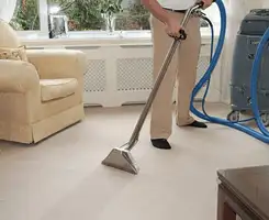 Carpet cleaning professional removing dirt and stains with a hot-water extraction tool in a home, Oakland, CA.