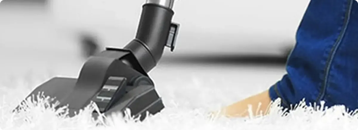 Close-up of a professional vacuuming a white carpet in San Lorenzo.